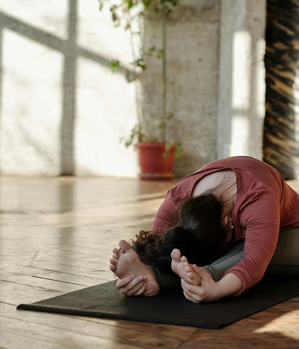 Woman performing a morning yoga stretch in a sunlit room.